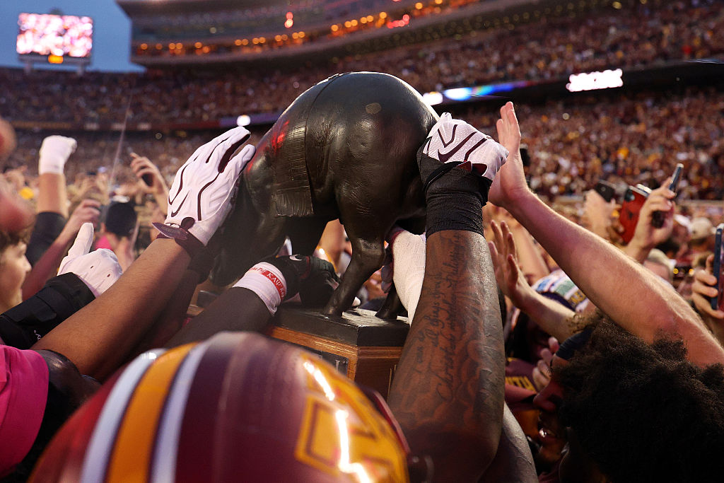 Minnesota Gophers football team on the field during a game, uniting fans in maroon and gold.